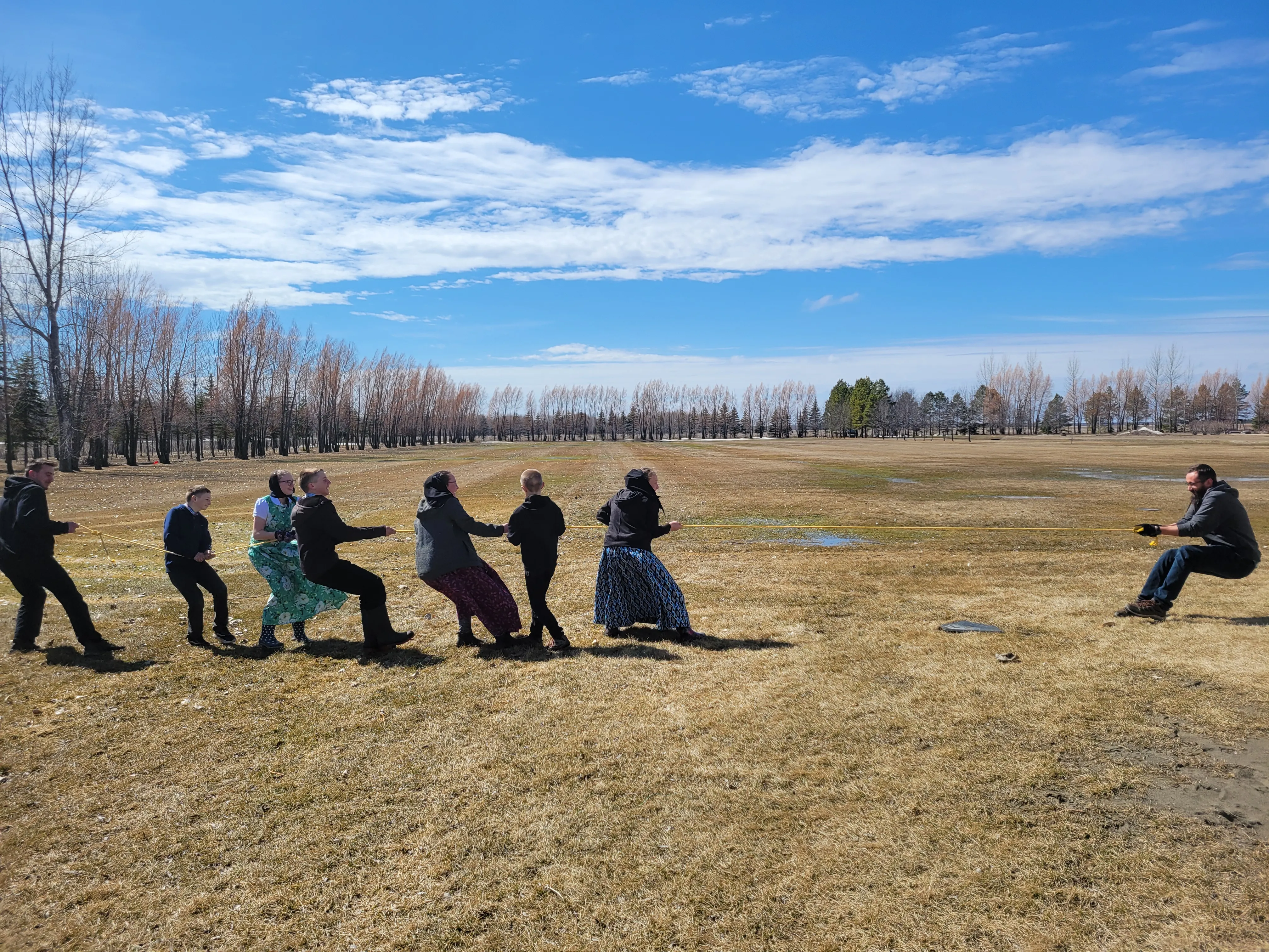 Students and a teacher participating in a tug-of-war activity